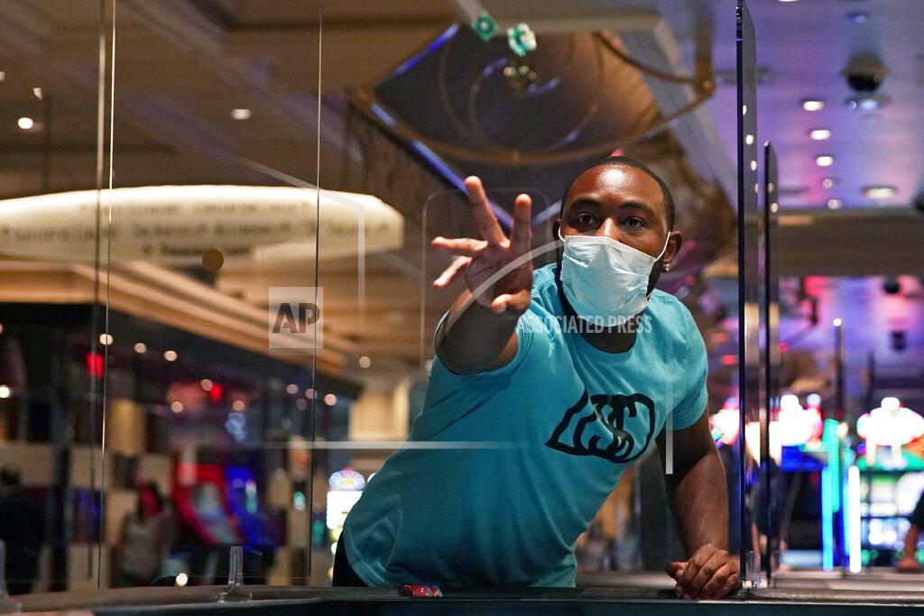 John Locher FILE - In this June 4, 2020 file photo, a man plays craps at the reopening of the Bellagio hotel and casino. in Las Vegas. With more casinos and businesses reopening and health officials charting a recent uptick in COVID-19 cases, Nevada lawmakers on Friday, June 12, 2020 approved Gov. Steve Sisolak's plan to plug an $812 million budget deficit blamed on the coronavirus pandemic. An oversight committee vote to approve the Democratic governor's plan was along party lines, with Republicans united against it. State tax revenues plunged after Sisolak closed business and casinos in mid-March to prevent the spread of the communicable COVID-19 illness. (AP Photo/John Locher, File)