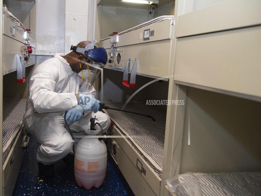 Seaman Apprentice Kaylianna Geni FILE - In this April 12, 2020, file photo provided by the U.S. Navy, U.S. Navy Aviation Ordnanceman Airman Brian Miller, of Mineral Wells, Texas, disinfects a berthing aboard the aircraft carrier USS Theodore Roosevelt (CVN 71) with a multi-surface sanitizer. The U.S. Navy says that after weeks of work, all of the roughly 4,800 sailors on the coronavirus-stricken USS Theodore Roosevelt aircraft carrier have been tested for the virus. The ship has been sidelined in Guam since March 27, moving sailors ashore, testing them and isolating them for nearly a month.(Mass Communication Specialist Seaman Kaylianna Genier/U.S. Navy via AP, File)