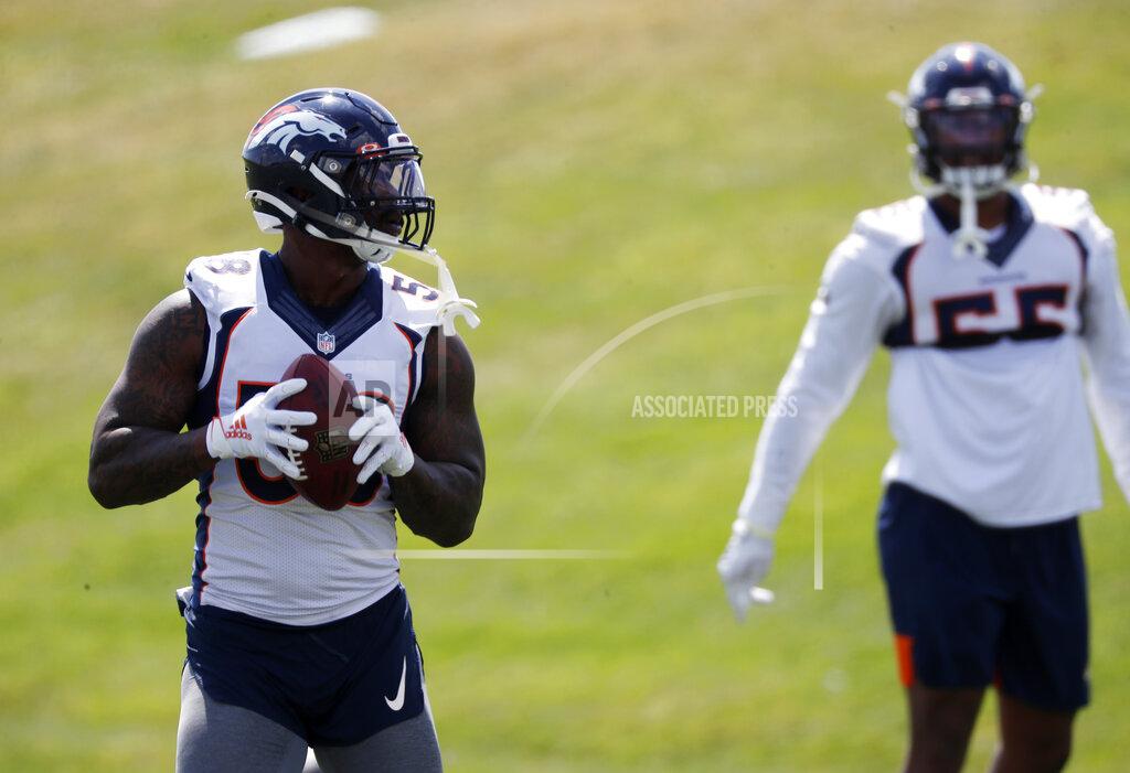 Denver Broncos outside linebacker Von Miller, left, throws a pass to outside linebacker Bradley Chubb as they take part in an NFL football practice Tuesday, Aug. 27, 2019, at the team's headquarters in Englewood, Colo. (AP Photo/David Zalubowski)