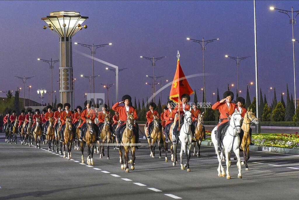 Uncredited FIE - In this May 9, 2020, photo, Turkmenistan's soldiers dressed in national uniforms ride their horses during the celebration of the 75th anniversary of the Nazi defeat in World War II in Ashgabat, Turkmenistan. As with North Korea, there is significant doubt about Turkmenistan's claim of zero cases. Authorities in the secretive and authoritarian Central Asian nation of 6 million have rejected allegations they're hiding information about the outbreak. And yet health officials have recommended people wear masks and keep a distance of 2 meters (7 feet) from each other in public places. (AP Photo,File)