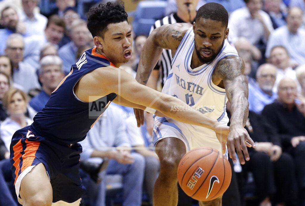 Gerry Broome Virginia's Kihei Clark, left, and North Carolina's Seventh Woods, right, reach for the ball during the first half of an NCAA college basketball game in Chapel Hill, N.C., Monday, Feb. 11, 2019. (AP Photo/Gerry Broome)