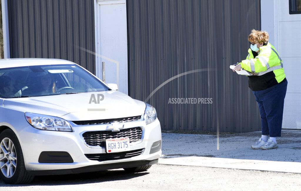 Volunteer Pam Bean greets people at the Sheffield Fire Department produce distribution on Friday, April 3, 2020, in Sheffield Township, Ohio. (Warren Dillaway/The Star-Beacon via AP)