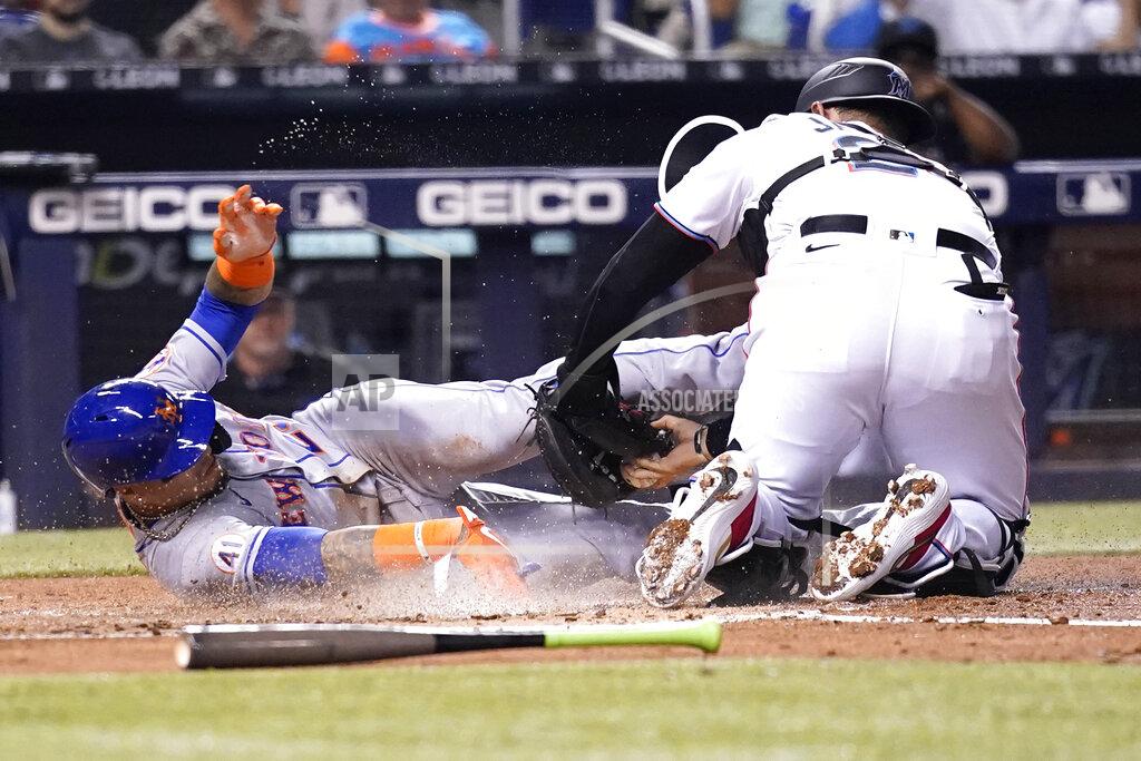 Lynne Sladky New York Mets' Javier Baez, left, scores past Miami Marlins catcher Alex Jackson, right, during the first inning of a baseball game, Wednesday, Aug. 4, 2021, in Miami. (AP Photo/Lynne Sladky)