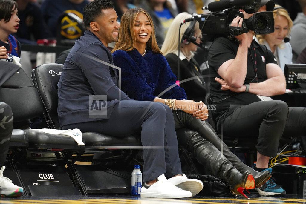 David Zalubowski Denver Broncos quarterback Russell Wilson, left, jokes with his wife, rap star Ciara, as they sit courtside in the second half of Game 4 of an NBA basketball first-round Western Conference playoff series, Sunday, April 24, 2022, in Denver. (AP Photo/David Zalubowski)