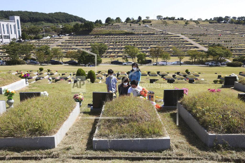Ahn Young-Joon Family members wearing face masks pay respects to their ancestral cemetery ahead of Chuseok holiday, the Korean version of Thanksgiving Day, at a cemetery in Paju, South Korea, Sunday, Sept. 27, 2020. South Korea's national cemeteries will be closed during the upcoming Chuseok holiday during the five-day holidays from Sept. 30 to Oct. 4 to prevent the spread of the coronavirus.(AP Photo/Ahn Young-joon)