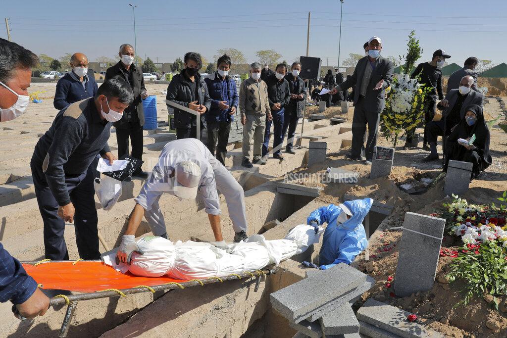 Ebrahim Noroozi The body of a person who died from COVID-19 is interred as mourners look on, at the Behesht-e-Zahra cemetery on the outskirts of Tehran, Iran, Sunday, Nov. 1, 2020. (AP Photo/Ebrahim Noroozi)