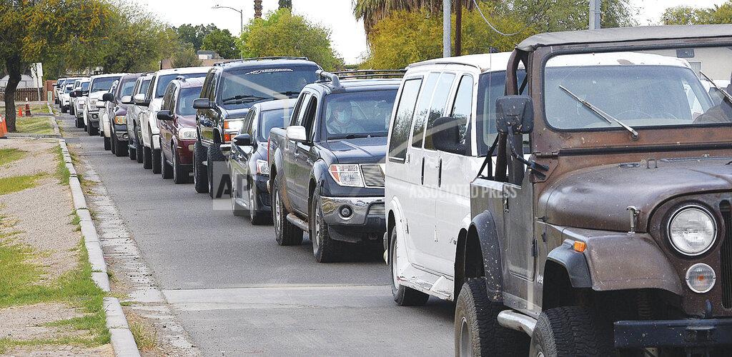 Randy Hoeft Vehicles are lined up bumper to bumper on Fern Street from Somerton Avenue to Union Avenue early Monday, March 15, 2021 during Sunset Health's mass vaccination program for farmworkers at Joe Munoz Park. (Randy Hoeft/Yuma Sun via AP)