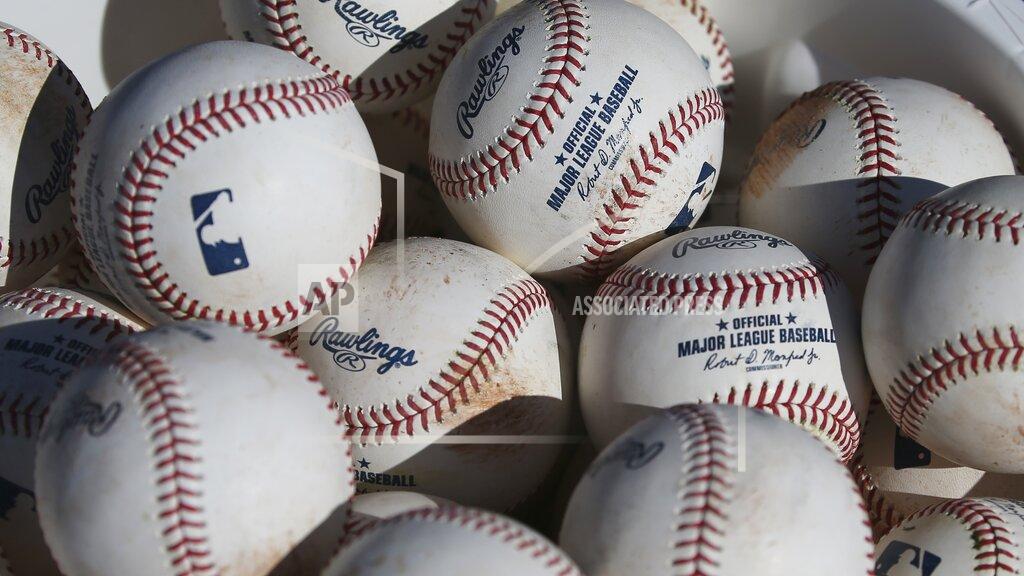 Ross D. Franklin FILE - In this Feb. 14, 2020, file photo, baseballs sit in a bucket after they were used for fielding practice during spring training baseball workouts for pitchers and catchers at Cleveland Indians camp in Avondale, Ariz. Major League Baseball revamped its spring training exhibition schedule because of the pandemic, cutting travel for Florida-based teams in an effort to avoid the novel coronavirus, the league announced Friday, Feb. 12, 2021. (AP Photo/Ross D. Franklin, File)