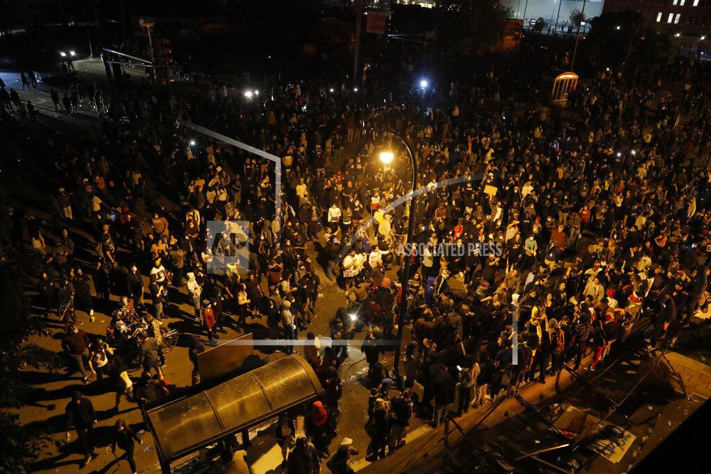 Julio Cortez Protesters are seen from the roof of the Minneapolis police 3rd Precinct building Thursday, May 28, 2020, in Minneapolis. Protests over the death of George Floyd, a black man who died in police custody Monday, broke out in Minneapolis for a third straight night. (AP Photo/Julio Cortez)