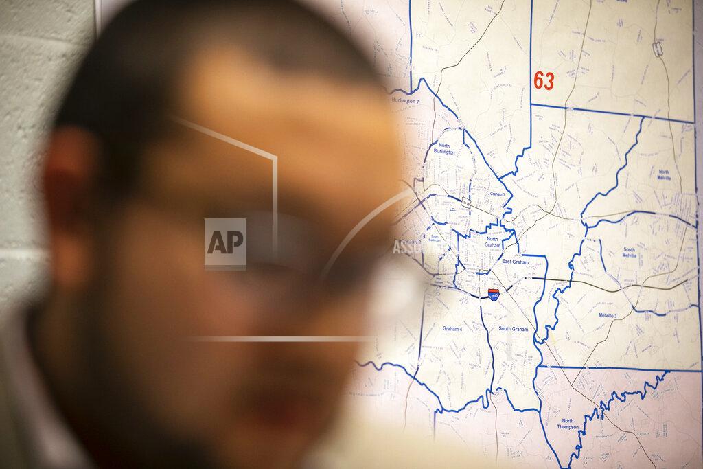 Jacquelyn Martin FILE - In this Tuesday, March 10, 2020 file photo, Ricky Hurtado, the first Latino candidate to run for North Carolina's House of Representatives, works in his campaign headquarters, in Graham, N.C., in front of a map of Alamance County. Although he won in November, Hurtado is struggling to understand how there was a shift among Latinos toward Donald Trump in the election. The president's strong performance with Cuban Americans in South Florida narrowed the traditional Democratic edge in Miami-Dade County and helped put Florida in Trump’s column. In Texas, Trump won tens of thousands of new supporters in predominantly Mexican American communities along the border. (AP Photo/Jacquelyn Martin)