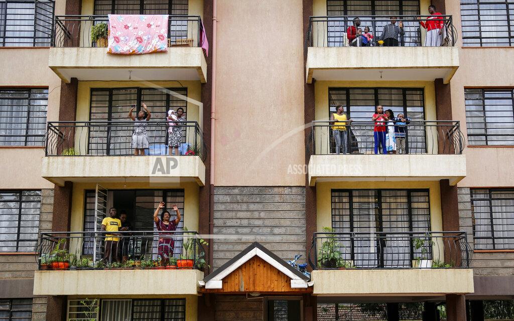 Brian Inganga FILE - In this Sunday, May 17, 2020 file photo, residents sing from their apartment balconies as Rev. Paul Machira preaches and sings to them below, due to restrictions on public religious services to curb the spread of the coronavirus, at an apartment block in Nairobi, Kenya. The COVID-19 pandemic is testing the patience of some religious leaders across Africa who worry they will lose followers, and funding, as restrictions on gatherings continue. (AP Photo/Brian Inganga, File)