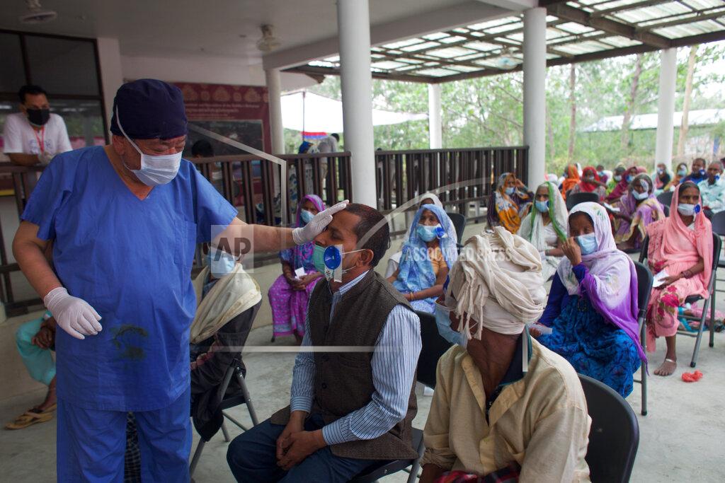 Bikram Rai Nepal’s “God of Sight”, Dr. Sanduk Ruit checks a patient's eye sight after his eye patches are removed at an eye camp in Lumbini, 288 kilometers (180 miles) south west of Kathmandu, Nepal, March 31, 2021. The eye doctor renowned for his innovative and inexpensive cataract surgery for the poor is taking his work beyond the Himalayan mountains to other parts of the world so there is no more unnecessary blindness in the world. Ruit, who has won many awards for his work and performed some 130,000 cataract surgery in the past three decades, is aiming to expand his work beyond the borders of his home country and the region to go globally. (AP Photo/Bikram Rai)