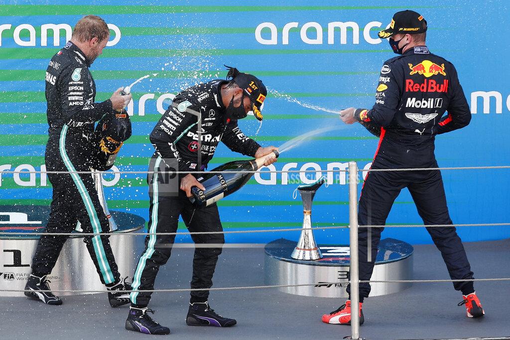 Alejandro Garcia Winner Mercedes driver Lewis Hamilton of Britain, center, celebrates on the podium besides second placed Red Bull driver Max Verstappen of the Netherlands, right, and third placed Mercedes driver Valtteri Bottas of Finland after the Formula One Grand Prix at the Barcelona Catalunya racetrack in Montmelo, Spain, Sunday, Aug. 16, 2020. (Alejandro Garcia, Pool via AP)