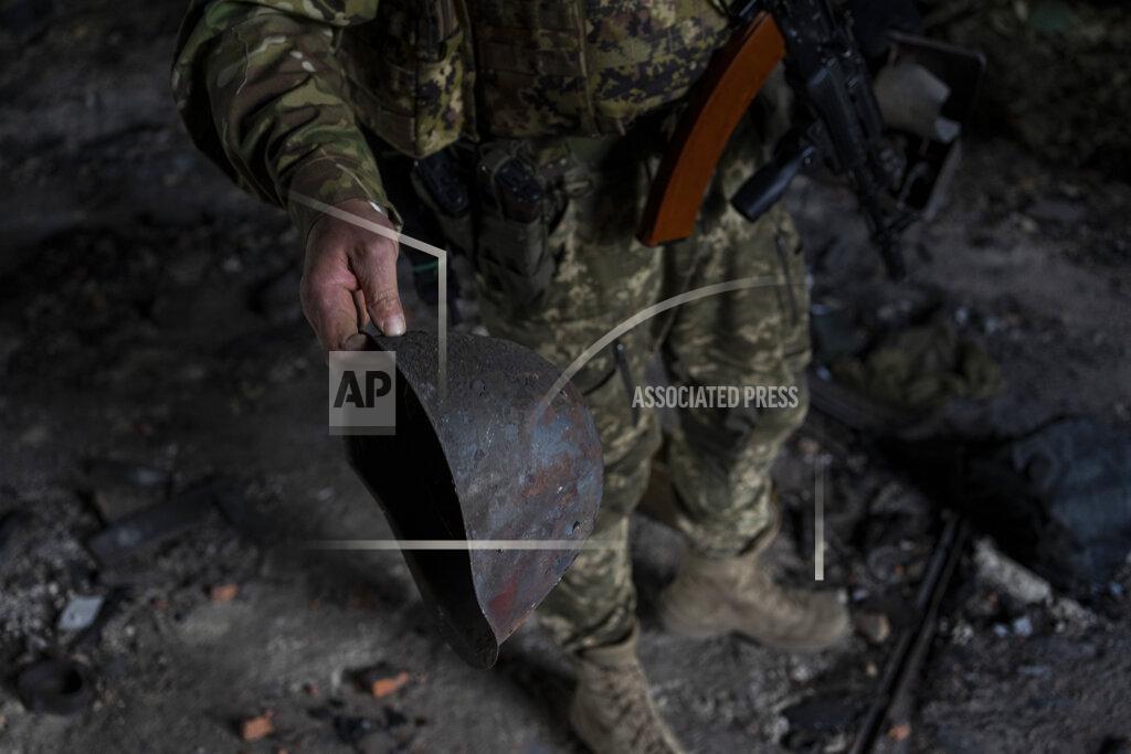 Bernat Armangue A Ukrainian serviceman holds the helmet used by Russian troops inside a school damaged during a battle between Russian and Ukrainian forces in the village of Vilkhivka, on the outskirts of Kharkiv, in eastern Ukraine, Friday, May 20, 2022. (AP Photo/Bernat Armangue)