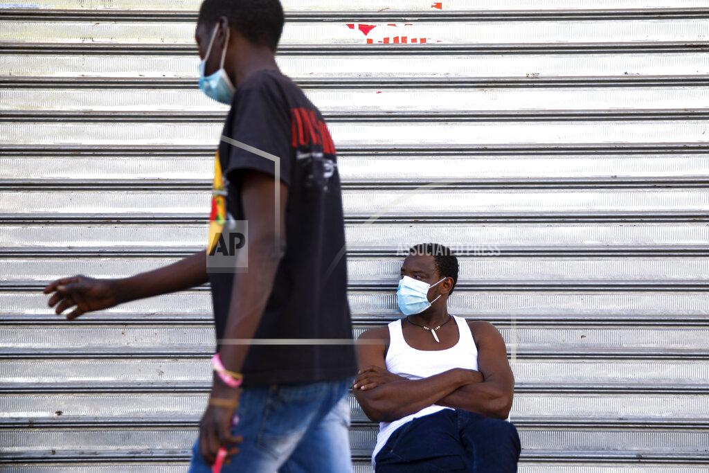 Sudanese migrant sits outside a closed shop in south Tel Aviv, Israel, Sunday, Oct. 25, 2020. After Israel and Sudan agreed this month to normalize ties, some 6,000 Sudanese migrants in Israel are again fearing for their fate. Israel has long grappled with how to deal with its tens of thousands of African migrants. (AP Photo/Oded Balilty)
