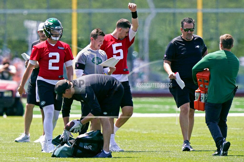 Kathy Willens Quarterbacks Zach Wilson (2) and Mike White (5) take a break as offensive coordinator Mike LaFleur shouts out instructions during a break in an NFL football practice, Thursday, May 27, 2021, in Florham Park, N.J. (AP Photo/Kathy Willens)