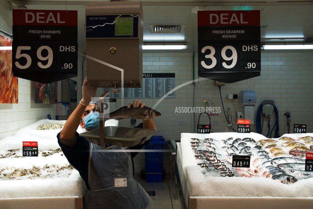 Jon Gambrell In this Sunday, April 19, 2020 photo, fishmonger Ramu Subedi of Nepal weighs a fish at a Carrefour supermarket while wearing a face mask amid the coronavirus pandemic in Dubai, United Arab Emirates. Frontline workers across Arab Gulf countries are uniquely almost entirely foreigners. They risk exposure to the virus, ensuring patients are cared for, streets are sanitized, packages are delivered and grocery stores are stocked. The global pandemic has drawn attention to just how vital foreigners are to the Arab Gulf countries where they work. (AP Photo/Jon Gambrell)