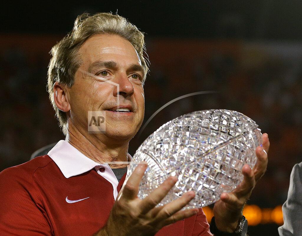 David J. Phillip FILE - In this Jan. 7, 2013, file photo, Alabama head coach Nick Saban holds The Coaches Trophy after the BCS National Championship college football game against Notre Dame, in Miami. Alabama won 42-14. Alabama has claimed three of the decade's first six national titles while Auburn, Florida State and Ohio State have each won one. The Tide is the preseason No. 1 team again. (AP Photo/David J. Phillip, File)