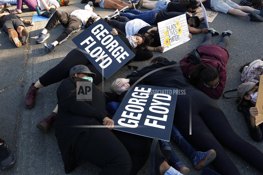 Rich Pedroncelli Protesters lay silent for 8 minutes and 46 seconds, Friday, June 5, 2020, during a demonstration to honor George Floyd, near the home of Sacramento Mayor Darrell Steinberg in Sacramento, Calif. Floyd died after being restrained by Minneapolis police officers on Memorial Day, May 25, 2020. (AP Photo/Rich Pedroncelli)