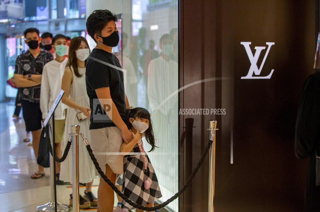 Gemunu Amarasinghe Patrons stand in a line to enter the Louis Vuitton shop at the upmarket shopping mall Siam Paragon in Bangkok, Thailand, Sunday, May 17, 2020. Thai authorities allowed department stores, shopping malls and other businesses to reopen from Sunday, selectively easing restrictions meant to combat the coronavirus. (AP Photo/ Gemunu Amarasinghe)