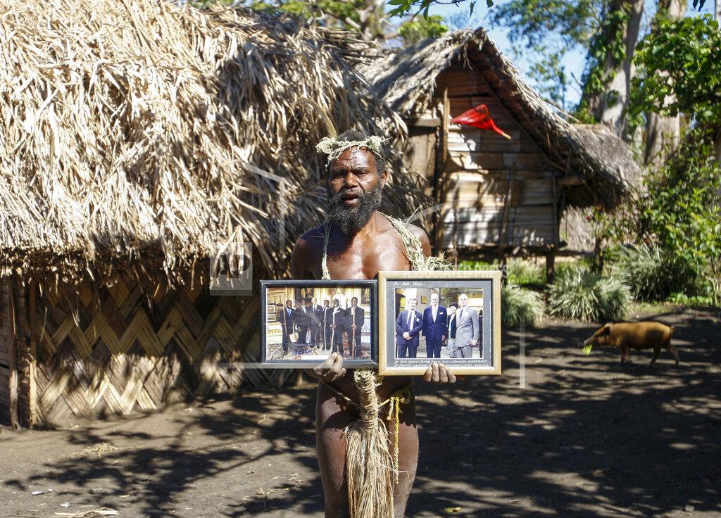 Nick Perry FILE - In this Sunday, May 31, 2015 file photo, Albi Nagia poses with photographs of Prince Philip in Yakel, Tanna island, Vanuatu. A tribe in the remote island nation of Vanuatu who saw Prince Philip as a god will greet his death with ritual wailing and ceremonial dancing, an expert said. The group, based in villages on the island of Tanna in the former Anglo-French colony, revered the Duke of Edinburgh and believed him to be a reincarnation of an ancient warrior who left the island to fight a war. (AP Photo/Nick Perry, File)