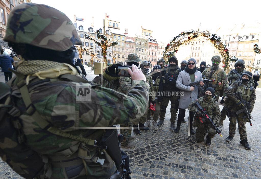 Czarek Sokolowski Military fans, dressed as soldiers and the charity's red heart symbol, pose for a photo as they collect money for Poland's most popular nationwide fundraiser for health purposes, the Great Orchestra of Christmas Charity, that was postponed by two weeks due to the pandemic, in downtown Warsaw, Poland, on Sunday, Jan. 31, 2021. Anti-government protesters angry about a near-total abortion ban suspended their marches for the weekend to show solidarity and ensure that they didn't steal the spotlight from the event. (AP Photo/Czarek Sokolowski)