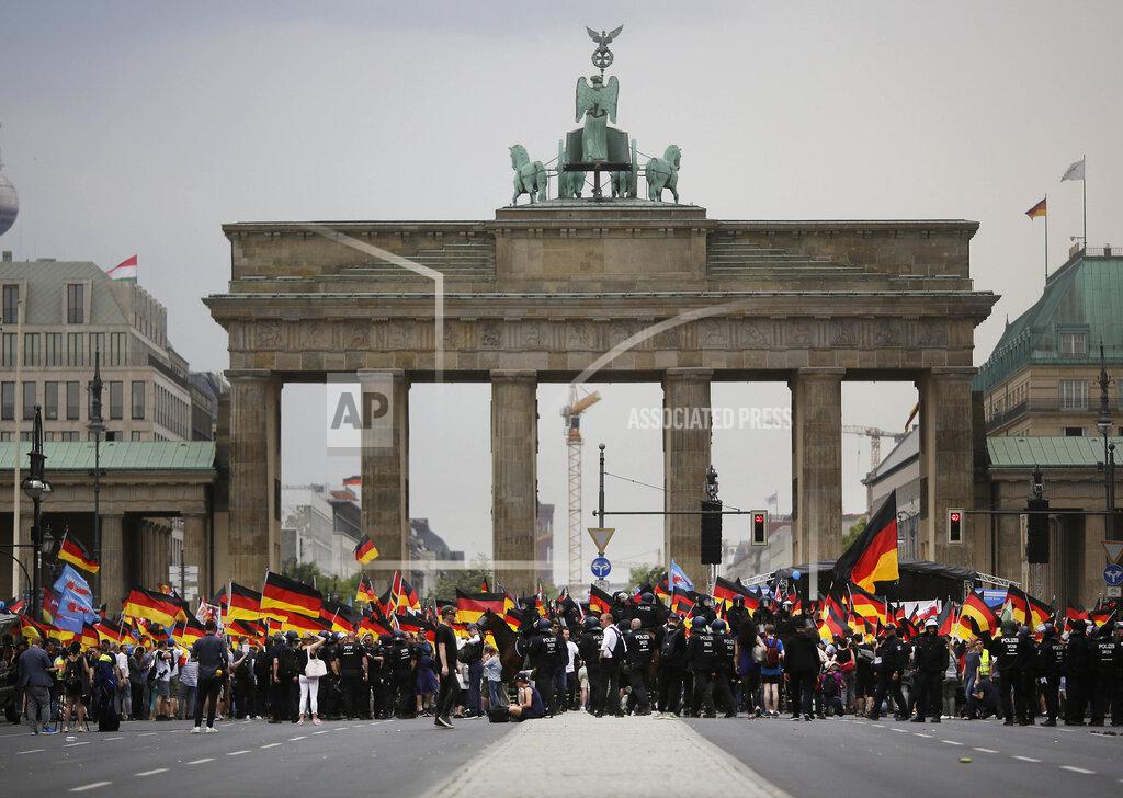 Markus Schreiber FILE - In this Sunday, May 27, 2018 file photo, AfD supporters wave flags in front of the Brandenburg Gate in Berlin, Germany. Migration is a side issue in this year's German election campaign for the national elections on Sept. 26, but that hasn't stopped the country's biggest far-right party from trying to play it up. (AP Photo/Markus Schreiber, File)