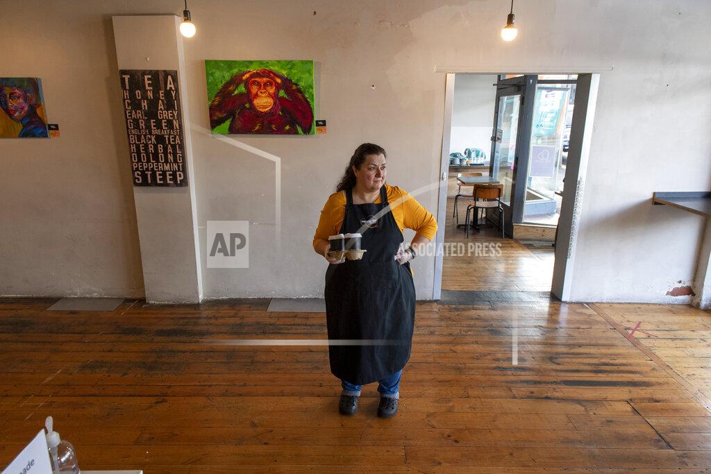 Cafe owner Maria Iatrou stands at her empty coffee shop in Melbourne, Monday, July 6, 2020. As Australia is emerging from pandemic restrictions, the Victoria state capital Melbourne is buckling down with more extreme and divisive measures that are causing anger and igniting arguments over who is to blame as the disease spreads again at an alarming rate. (AP Photo/Andy Brownbill)