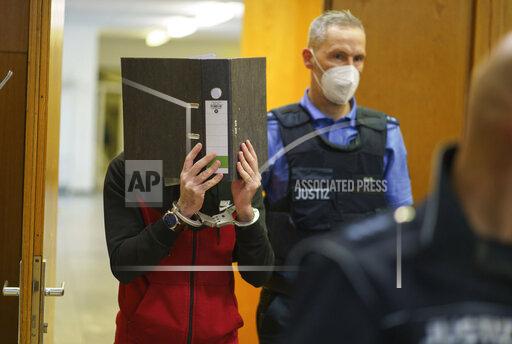 The Iraqi Taha Al-J. is led into the courtroom at Frankfurt's Higher Regional Court before the verdict is pronounced Frankfurt, Germany, Nov. 30, 2021. The Federal Prosecution accuses him of genocide, crimes against humanity, war crimes, human trafficking and murder. As a suspected member of the terrorist militia IS, he is alleged to have held a Yazidi woman and her daughter as slaves and abused them. In the process, he allegedly tied up the five-year-old in Fallujah, Iraq, where the child died of thirst in agony, according to the indictment. (Frank Rumpenhorst/Pool via AP)