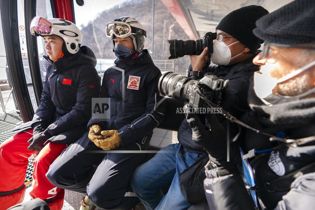 Mark Schiefelbein Photographers take photos of skiers as they ride in a gondola at the National Alpine Skiing Center in Yanqing on the outskirts of Beijing, Friday, Feb. 5, 2021. Beijing Olympic organizers showed off the downhill skiing venue and the world's longest bobsled and luge track Friday, one year ahead of the scheduled opening of the 2022 Olympic Winter Games. (AP Photo/Mark Schiefelbein)