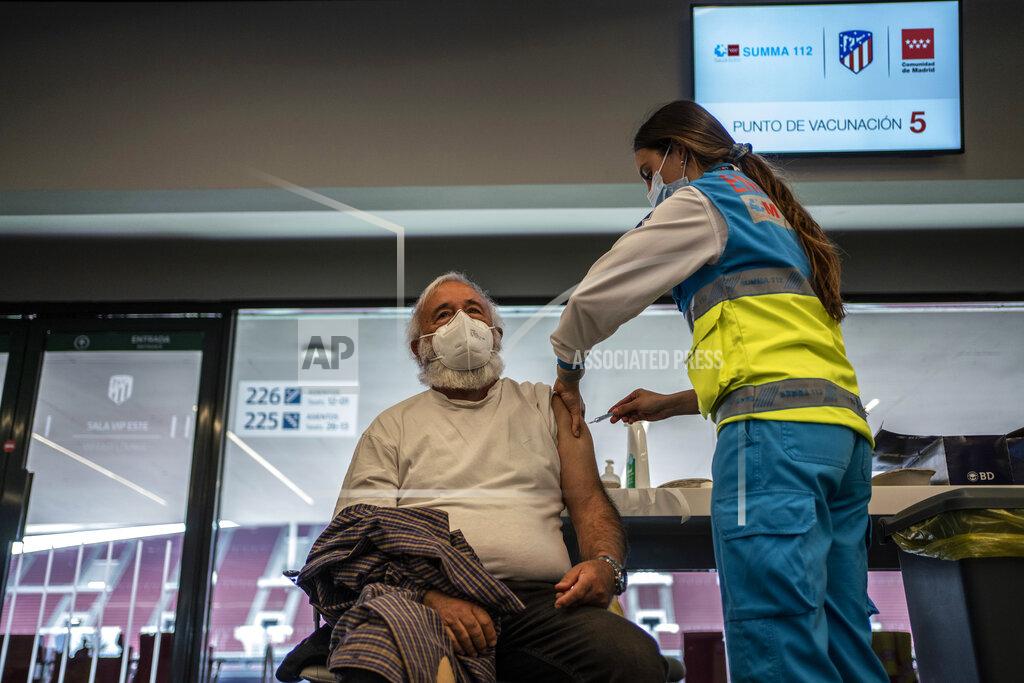 Olmo Calvo A worker from the Madrid Medical Emergency Service vaccinates a man against COVID-19 at the Wanda Metropolitano stadium, Madrid, Spain, March 30, 2021. Spain is trying to stamp out a new wave of COVID-19 among its youth thanks to a robust vaccination program that is widely supported. Spain like the rest of the European Union got off to a slow start to compared to the United States and Britain when the first vaccines were released. But it has quickly made up ground once deliveries by drug makers started flowing. (AP Photo/Olmo Calvo)