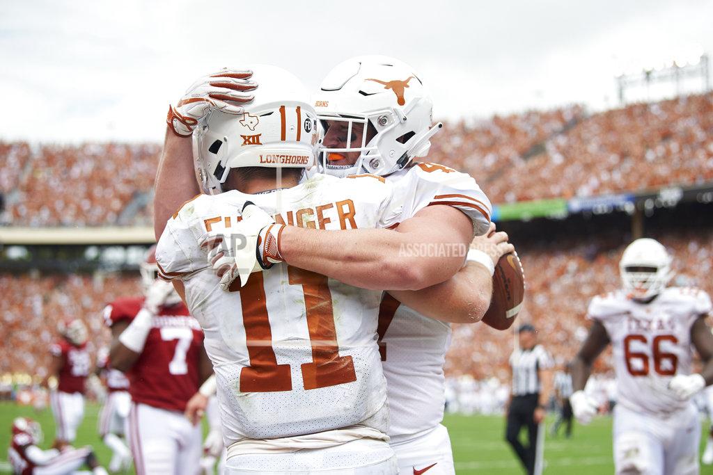 Cooper Neill Texas quarterback Sam Ehlinger (11) celebrates after scrambling for a 9-yard touchdown against Oklahoma with teammate Andrew Beck (47) during the first half of an NCAA college football game at the Cotton Bowl, Saturday, Oct. 6, 2018, in Dallas. (AP Photo/Cooper Neill)