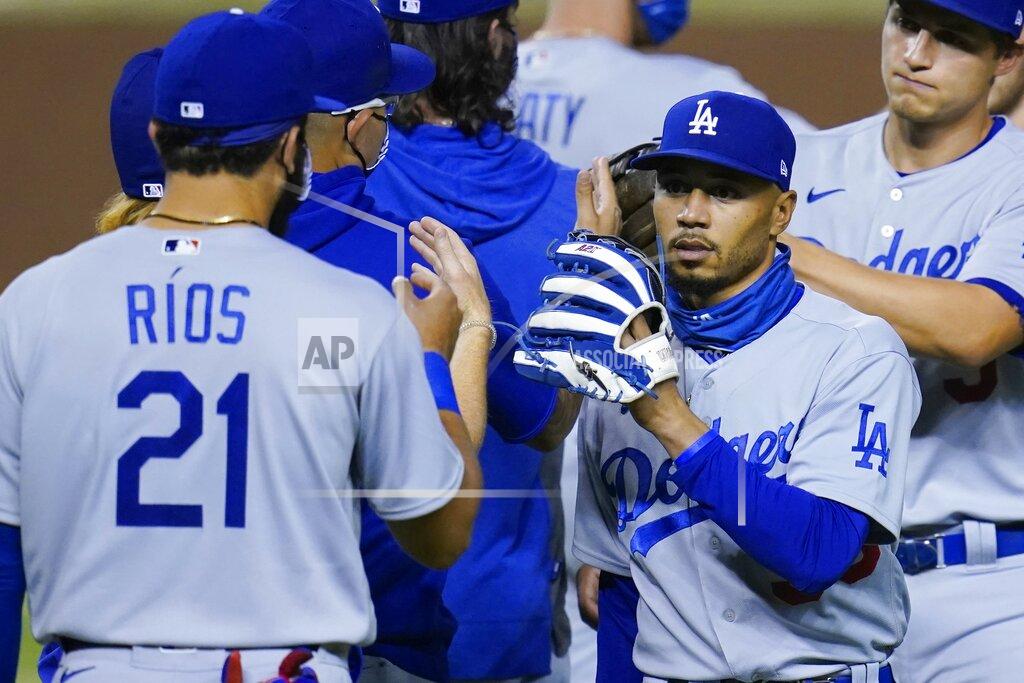 Los Angeles Dodgers' Mookie Betts, right, celebrates with Edwin Rios (21) and others after the Dodgers' 6-4 win over the Arizona Diamondbacks in 10 innings in a baseball game Wednesday, Sept. 9, 2020, in Phoenix. (AP Photo/Ross D. Franklin)