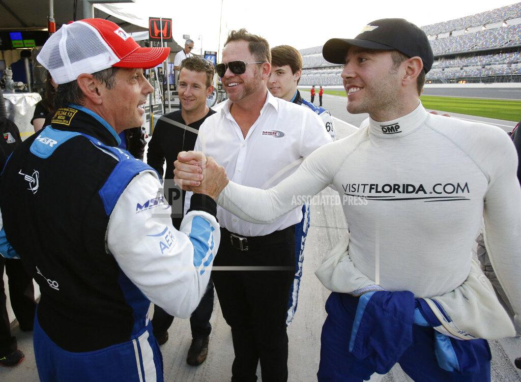 FILE - Oswaldo Negri, Jr., left, of Brazil, is congratulated by driver Michael Valiante, right, after winning the pole position for the IMSA 24-hour auto race as co-driver AJ Allmendinger, second from left, car owner Michael Shank, center, and co-driver Matt McMurry, second from right, celebrate on pit road at Daytona International Speedway in Daytona Beach, Fla., in this Thursday, Jan. 22, 2015, file photo. It took Michael Shank years to break into IndyCar even as the small-time team owner did everything the right way. The long winding road finally crossed the finish line for the biggest win in team history, an improbable Indianapolis 500 victory that gave Shank the validation he's sought for so long. (AP Photo/John Raoux, File)