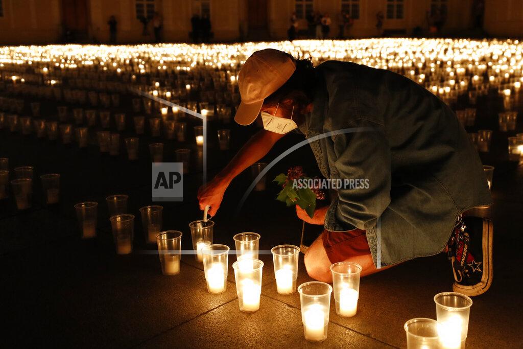 Petr David Josek A man lights up candles to commemorate victims of the COVD-19 pandemic at the Prague Castle in Prague, Czech Republic, Monday, May 10, 2021. The Czech Republic is massively relaxing its coronavirus restrictions as the hard-hit nation pays respect to nearly 30,000 dead. (AP Photo/Petr David Josek)