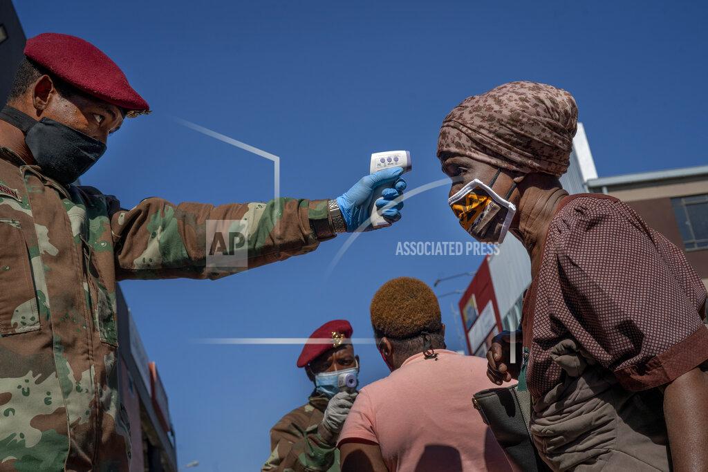 Jerome Delay FILE - In this file photo taken Wednesday May 20, 2020, South African National Defense Forces check the temperature of people near the Pan Africa taxi rank in Johannesburg's Alexandra township. South Africa is struggling to balance its fight against the coronavirus with its dire need to resume economic activity. The country with the Africa’s most developed economy also has its highest number of infections — more than 19,000. (AP Photo/Jerome Delay, File)