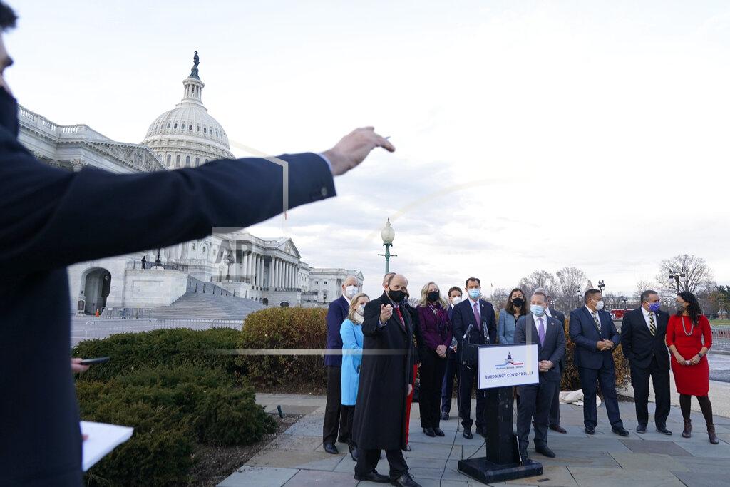 Jacquelyn Martin A reporter asks a question of the Problem Solvers Caucus including co-chairs Rep. Tom Reed, R-N.Y., pointing at left, and Rep. Josh Gottheimer, D-N.J., just right of podium, after they spoke to the media about the expected passage of the emergency COVID-19 relief bill, Monday, Dec. 21, 2020, on Capitol Hill in Washington. Congressional leaders have hashed out a massive, year-end catchall bill that combines $900 billion in COVID-19 aid with a $1.4 trillion spending bill and reams of other unfinished legislation on taxes, energy, education and health care. (AP Photo/Jacquelyn Martin)