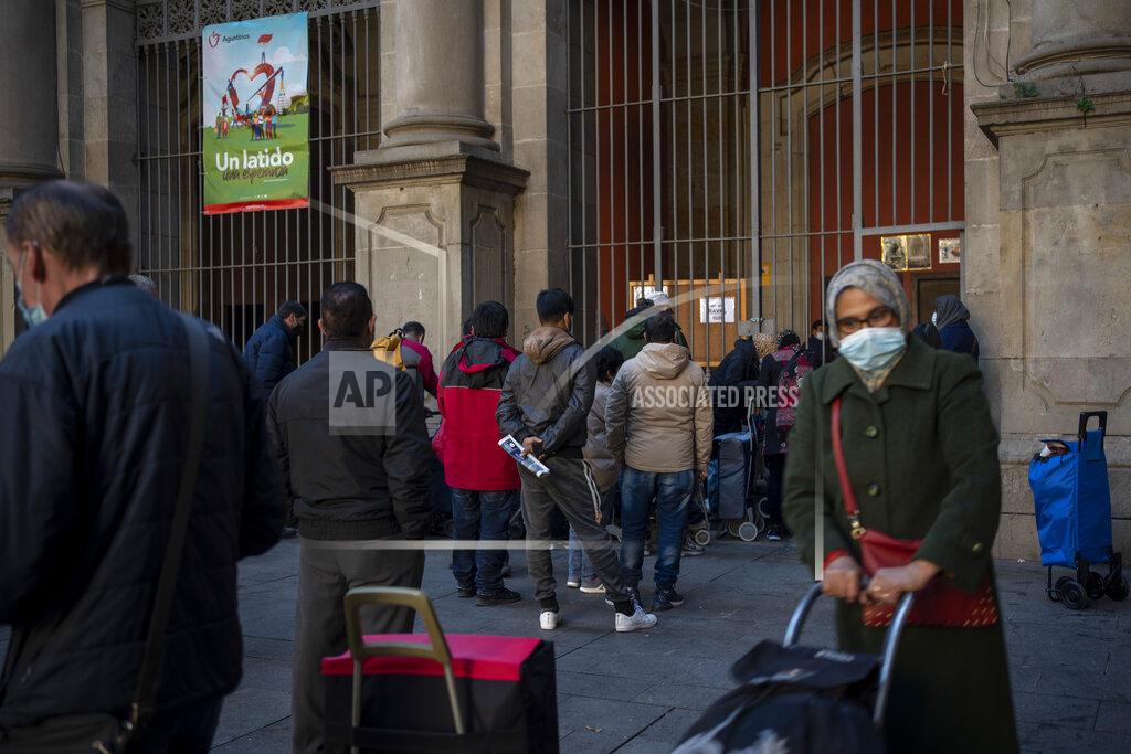 Emilio Morenatti People wait their turn to receive a weekly pack of donated food and supplies, outside a church in Barcelona, Spain, Wednesday, Feb. 3, 2021. Food requests have increased considerably in the last months as Spain has been in lockdown to fight the coronavirus pandemic. (AP Photo/Emilio Morenatti)