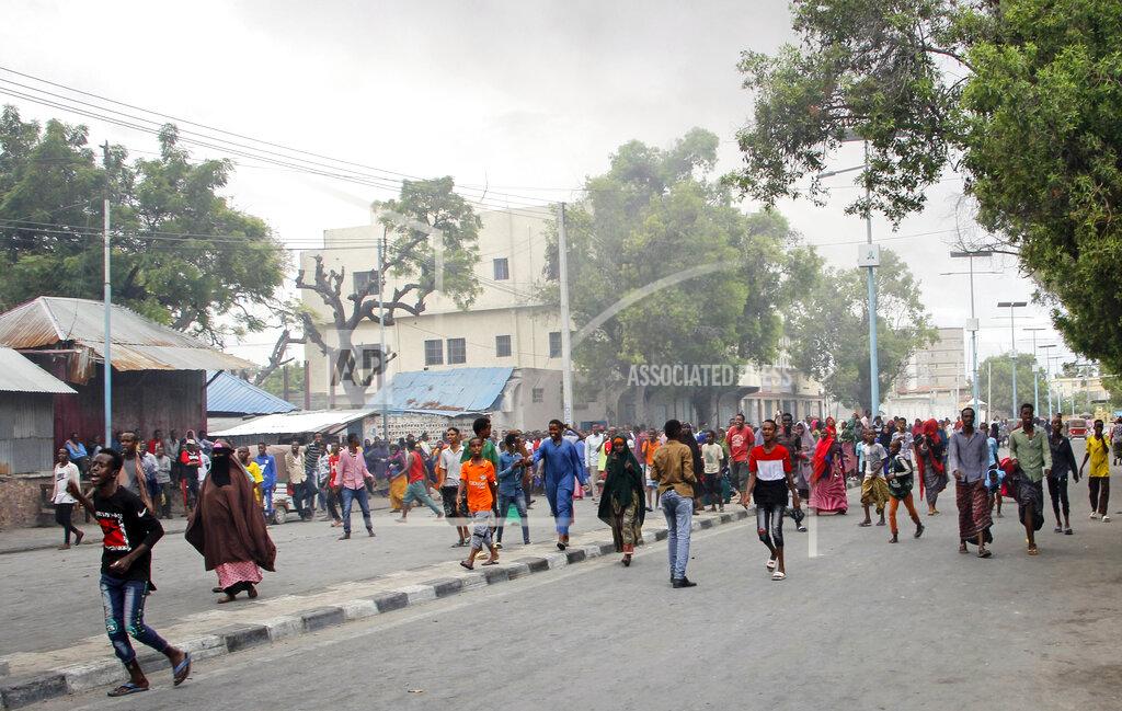 Somalis protest against the killing Friday night of at least one civilian during the overnight curfew, which is intended to curb the spread of the new coronavirus, on a street in the capital Mogadishu, Somalia Saturday, April 25, 2020. A police officer in Somalia's capital has been arrested in the fatal shooting of at least one civilian while enforcing coronavirus restrictions, a fellow police officer said, sparking protests that continued Saturday with crowds of angry young men burning tires and demanding justice. (AP Photo/Farah Abdi Warsameh)