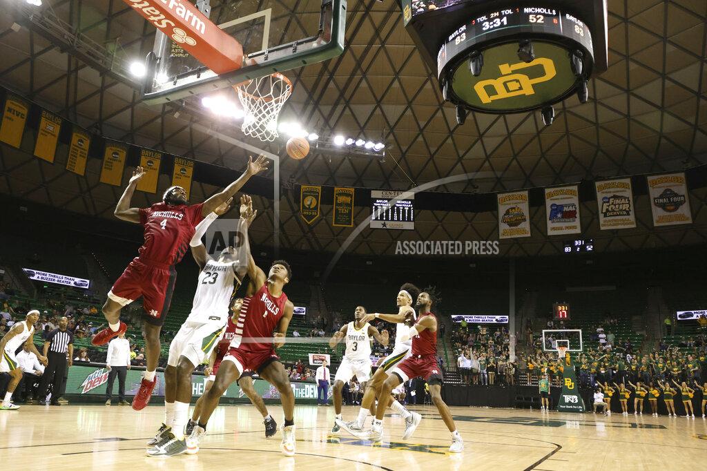 Rod Aydelotte Nicholls State guard Caleb Huffman, left, reaches for a rebound over Baylor forward Jonathan Tchamwa Tchatchoua (23) with help from teammate forward Emmanuel Little, right, in the second half of an NCAA college basketball game, Monday, Nov. 15, 2021, in Waco, Texas. (AP Photo/Rod Aydelotte)