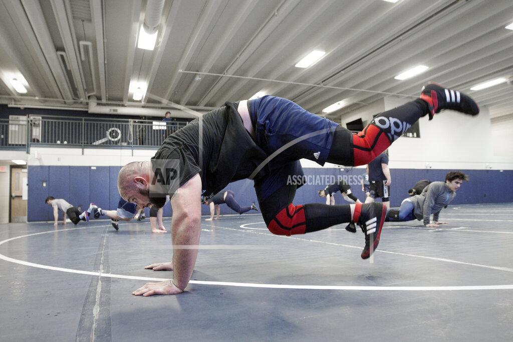 Nati Harnik In this March 2, 2020, photo, former Nebraska football player Tanner Farmer and current wrestler for Concordia University is seen during practice in Seward, Neb. A year ago Farmer was thought to be on the rise as an NFL draft prospect. He had started three years on Nebraska's offensive line and turned in a stellar performance at the Cornhuskers' pro day. It turned out he went undrafted, so he took a volunteer assistant's job with the Concordia football team and then, quite by accident, discovered he had one semester of eligibility to compete in another sport in the National Association of Intercollegiate Athletics. He chose wrestling. (AP Photo/Nati Harnik)