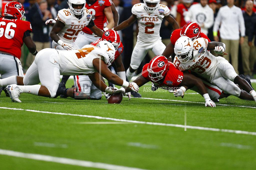 Butch Dill Texas defensive lineman Gerald Wilbon (94) recovers a fumble by Georgia as Georgia offensive lineman Trey Hill (55) reaches for the ball during the first half of the Sugar Bowl NCAA college football game in New Orleans, Tuesday, Jan. 1, 2019. (AP Photo/Butch Dill)