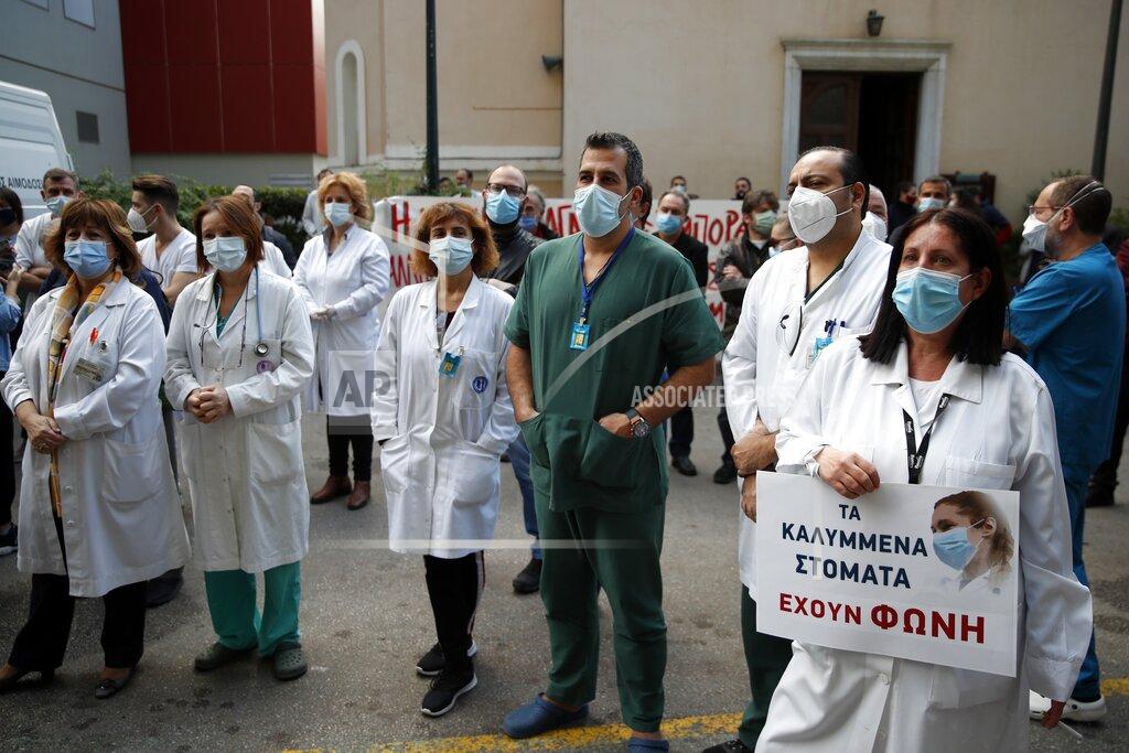 Thanassis Stavrakis Health workers wearing face masks to protect against the spread of the coronavirus, take part in a protest at Evangelismos hospital in Athens, Thursday, Nov. 12, 2020. State health workers' union staged protests at several hospitals around the country to demand more hiring. Greece has imposed a nationwide nightly curfew as the number of COVID-19 cases in the country continues to surge despite a lockdown. (AP Photo/Thanassis Stavrakis)
