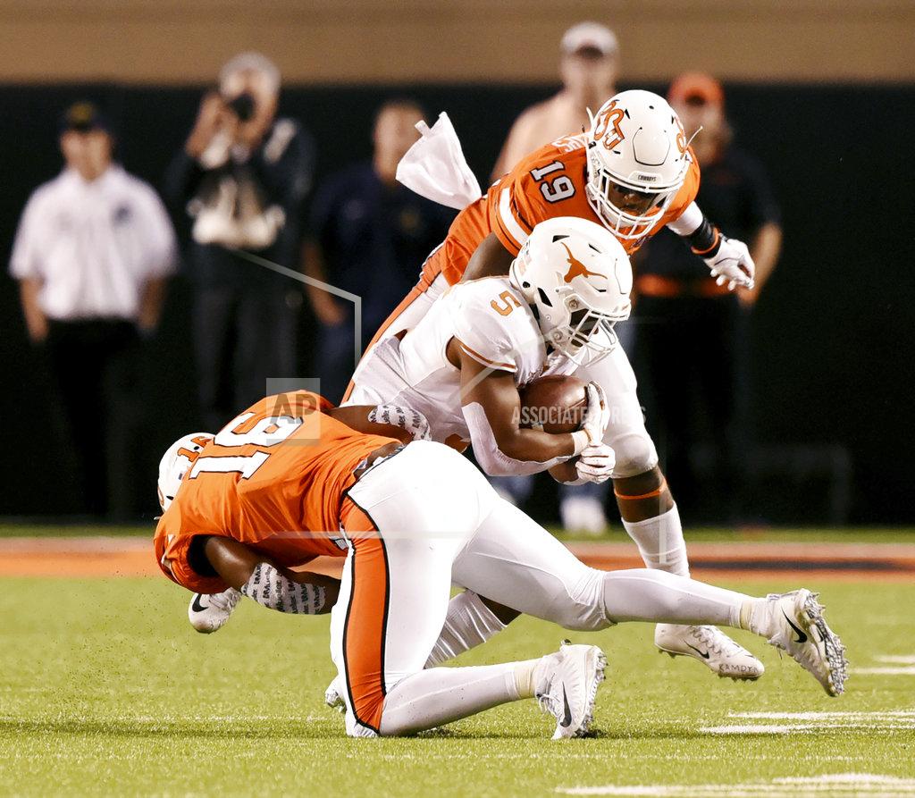 Brody Schmidt Texas running back Tre Watson (5) is brought down by Oklahoma State linebackers Devin Harper (16) and Justin Phillips (19) in the 2nd half of an NCAA college football game in Stillwater, Okla., Saturday, Oct. 27, 2018. Oklahoma State defeated Texas 38-35. (AP Photo/Brody Schmidt)