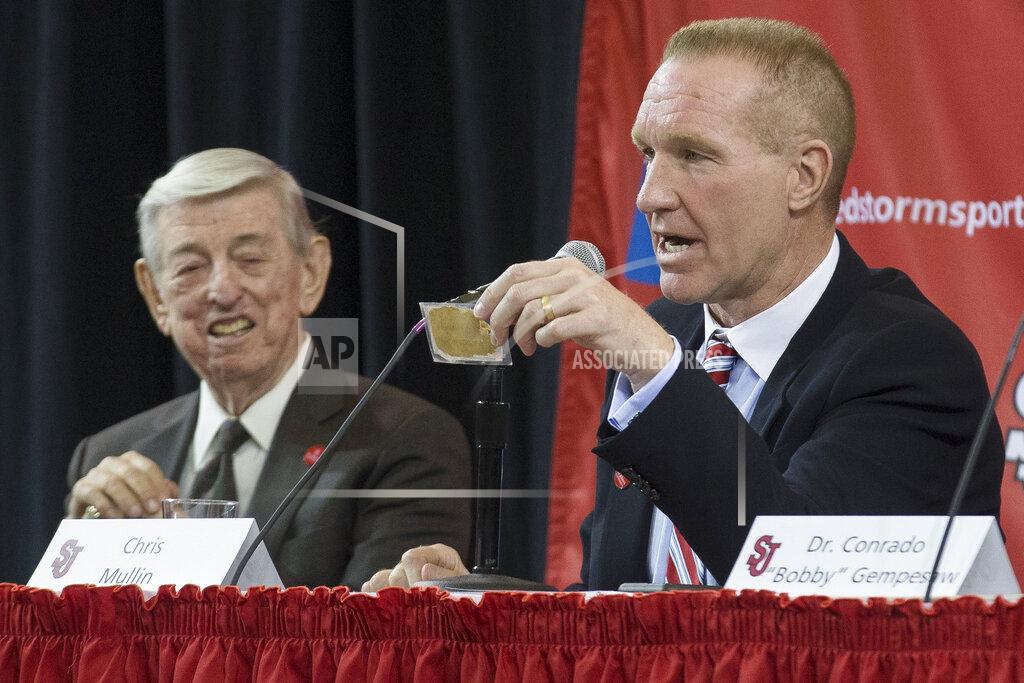 John Minchillo FILE - In this April 1, 2015, file photo, retired NBA basketball All-Star and St. John's alumnus Chris Mullin, holds a card given to him by his former coach Lou Carnesecca, left, that reads "Peacock today, Feather duster tomorrow" during a news conference to announce his hiring as St. John's men's basketball coach, in New York. The card was given to Carnesecca from former St. John's coach Joe Lapchick. Mullin felt in his heart that it was time to move on from St. John’s. Mullin stepped down as coach of the school he starred at as a player in the 1980s earlier this month after four years on the job. (AP Photo/John Minchillo, File)