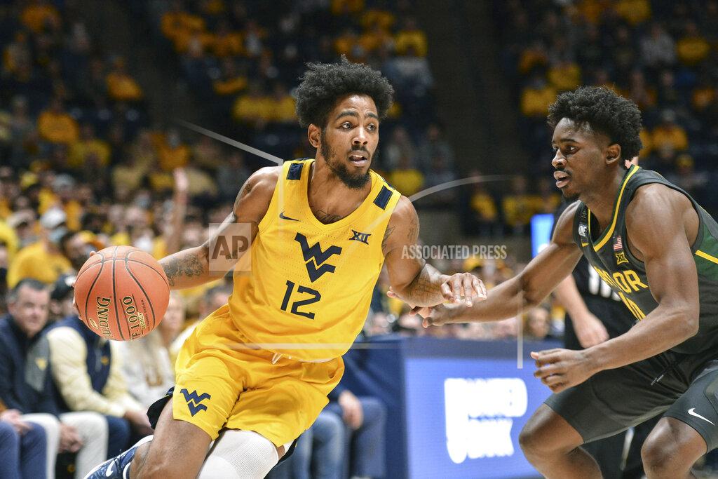 William Wotring West Virginia guard Taz Sherman (12) protects the ball from Baylor guard Adam Flagler (10) during the first half of an NCAA college basketball game in Morgantown, W.Va., Tuesday, Jan. 18, 2022. (William Wotring)