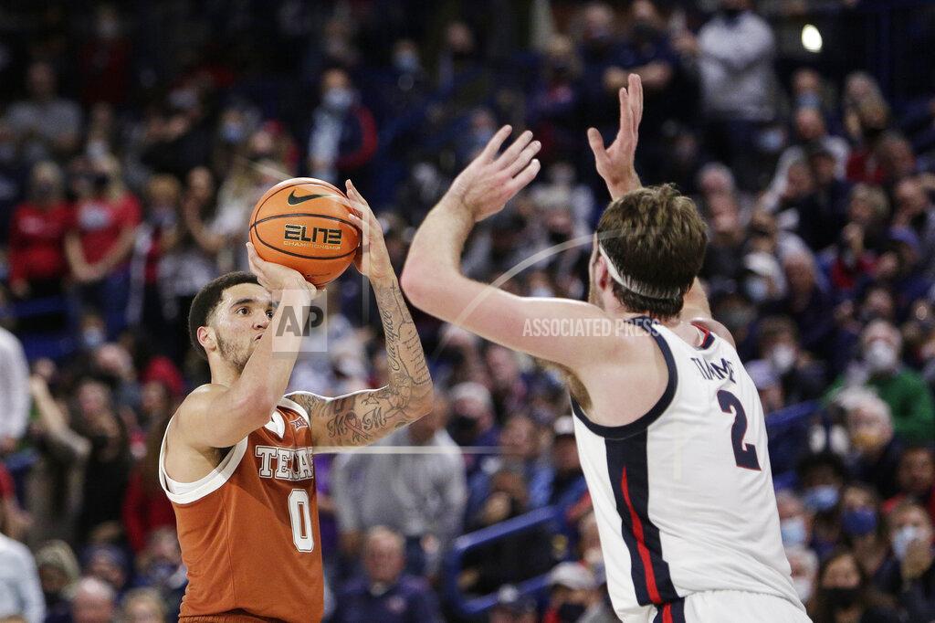 Young Kwak Texas forward Timmy Allen (0) shoots over Gonzaga forward Drew Timme (2) during the second half of an NCAA college basketball game, Saturday, Nov. 13, 2021, in Spokane, Wash. (AP Photo/Young Kwak)