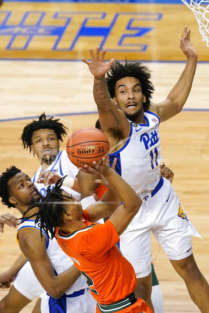 Gerry Broome Pittsburgh forward Justin Champagnie (11) blocks the shot of Miami guard Isaiah Wong (2) during the first half an NCAA college basketball game in the first round of the Atlantic Coast Conference tournament in Greensboro, N.C., Tuesday, March 9, 2021. (AP Photo/Gerry Broome)