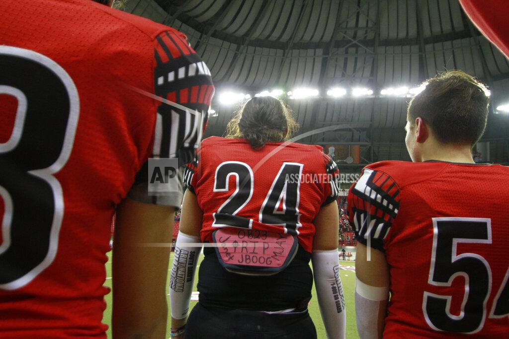 Stephen Groves In this Nov. 8, 2019 photo, Jayton Pease, (24) wear his late brother's nickname "JBOOG" on his back-plate pad to honor J'von Justice Shields, who killed himself in July, 2018 as Jayton prepares to play in the All Nations Conference championship game at "The Dome" in Vermillion, S.D.. He said his brother always dreamed of playing at "The Dome" where championship football games are decided. (AP Photo/Stephen Groves)