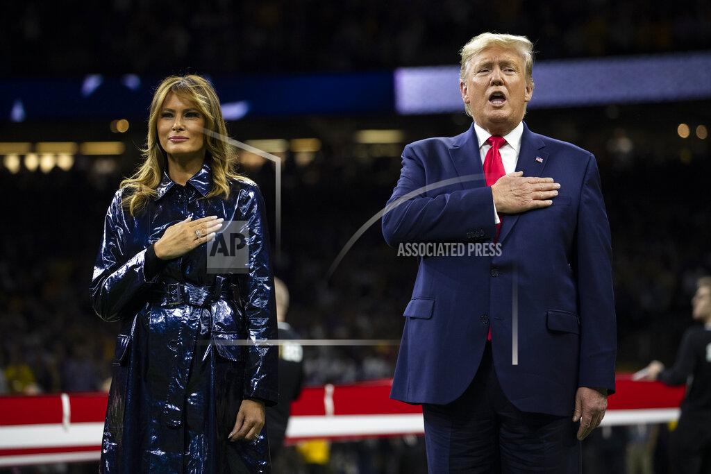Evan Vucci President Donald Trump and first lady Melania Trump stand for the national anthem before the beginning of the College Football Playoff National Championship game between LSU and Clemson, Monday, Jan. 13, 2020, in New Orleans. (AP Photo/ Evan Vucci)